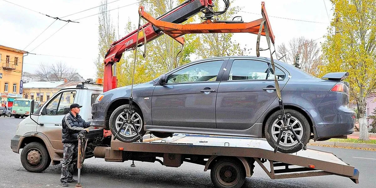 Эвакуатор перевозит легковой автомобиль по Тюмени